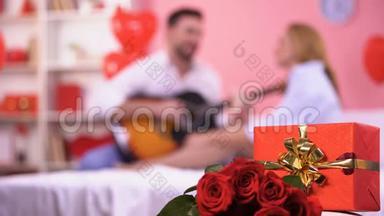 红色礼盒和一束玫瑰特写，男弹吉他浪漫旋律